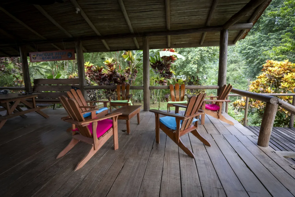 Pacuare River Ecolodge wooden deck with chairs, lush greenery background