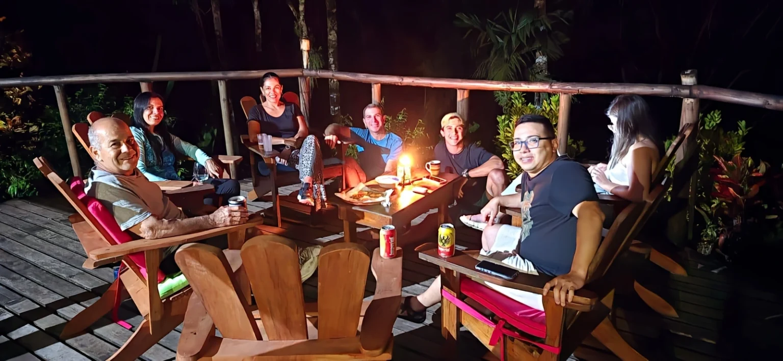 group enjoying evening on wooden deck with drinks and snacks