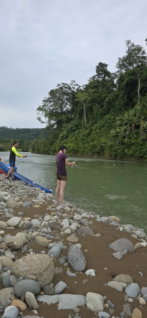 Pacuare River fishing, two people on rocky riverbank