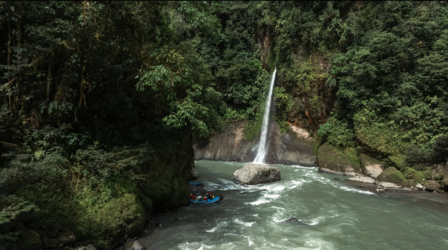 Pacuare River rafting near waterfall, lush forest backdrop