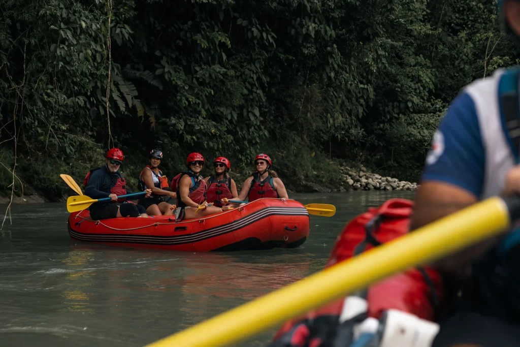 rafting group on Pacuare River in red raft with helmets